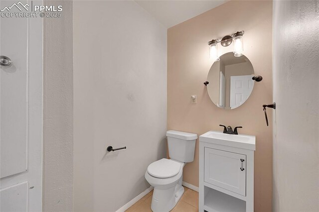 bathroom featuring tile patterned floors, toilet, vanity, and baseboards