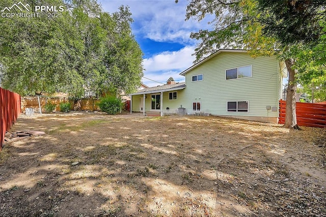 rear view of property featuring a fenced backyard