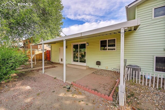 back of house featuring cooling unit, fence, and a patio area