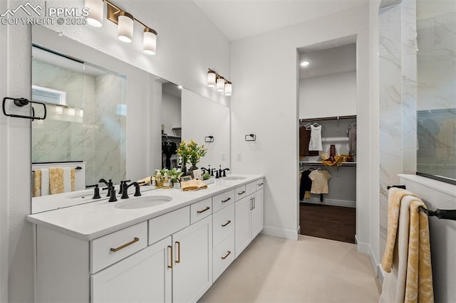 6678 Thimble Ct, Colorado Springs, CO 80924 - bathroom with a marble finish shower, a walk in closet, double vanity, and baseboards