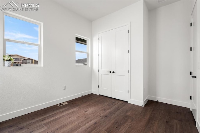 6678 Thimble Ct, Colorado Springs, CO 80924 - unfurnished bedroom with baseboards, dark wood-style floors, and a closet