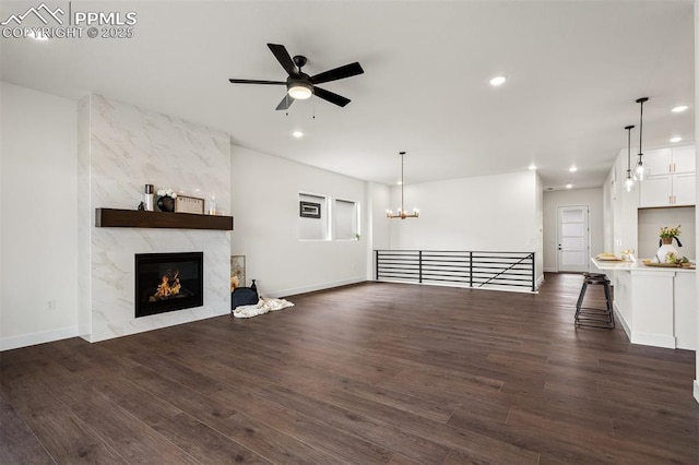 6678 Thimble Ct, Colorado Springs, CO 80924 - unfurnished living room featuring recessed lighting, dark wood-style flooring, a ceiling fan, a fireplace, and a chandelier