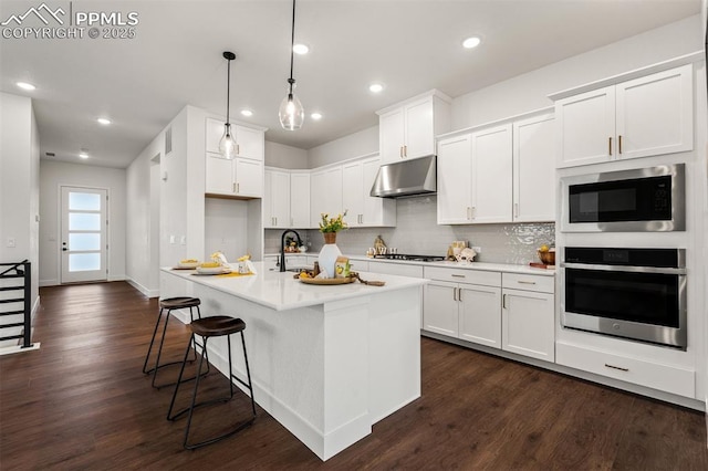 6678 Thimble Ct, Colorado Springs, CO 80924 - kitchen with stainless steel oven, under cabinet range hood, built in microwave, dark wood-style floors, and recessed lighting