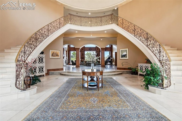 3870 S Club Dr, Colorado Springs, CO 80906 - tiled entryway featuring a towering ceiling, recessed lighting, stairway, decorative columns, and arched walkways
