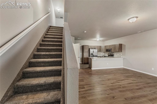 4691 Pleasant Port Vw, Colorado Springs, CO 80911 - staircase featuring a textured ceiling, baseboards, and wood finished floors