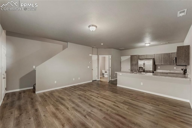 4691 Pleasant Port Vw, Colorado Springs, CO 80911 - interior space with open floor plan, light countertops, stainless steel fridge, dark wood-style flooring, and visible vents