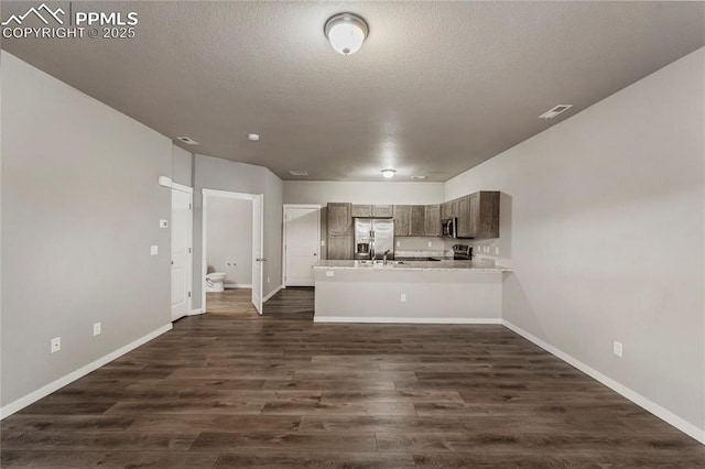 4691 Pleasant Port Vw, Colorado Springs, CO 80911 - kitchen with light countertops, dark wood-type flooring, baseboards, a peninsula, and appliances with stainless steel finishes