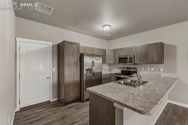 4691 Pleasant Port Vw, Colorado Springs, CO 80911 - kitchen featuring a sink, appliances with stainless steel finishes, a peninsula, visible vents, and dark wood-style flooring
