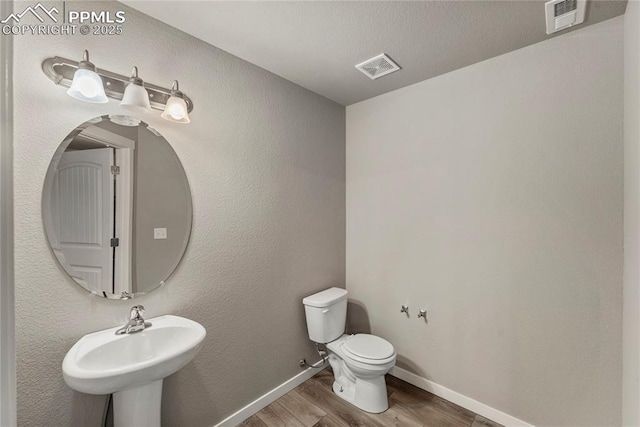 4691 Pleasant Port Vw, Colorado Springs, CO 80911 - half bath with toilet, visible vents, wood finished floors, and baseboards