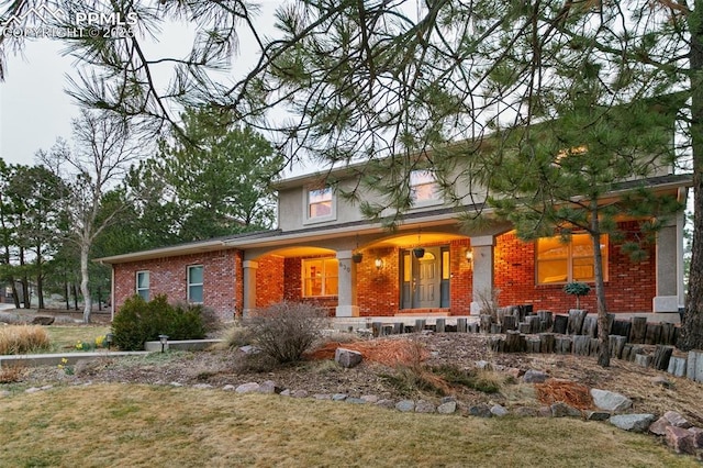 view of front of property featuring covered porch and brick siding