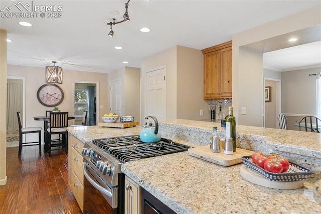 kitchen with dark wood-style flooring, stainless steel gas range, ornamental molding, recessed lighting, and light stone counters