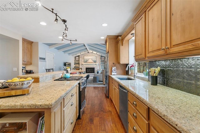 kitchen with vaulted ceiling with beams, a sink, dark wood-style floors, light stone countertops, and appliances with stainless steel finishes