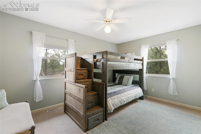carpeted bedroom featuring baseboards, visible vents, and a ceiling fan