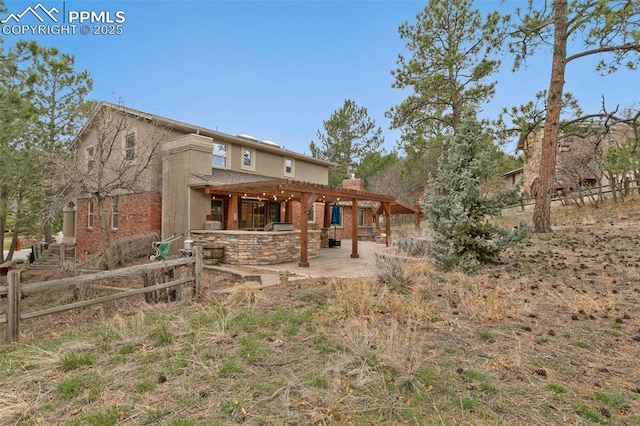 back of property featuring a pergola, stucco siding, and a patio area