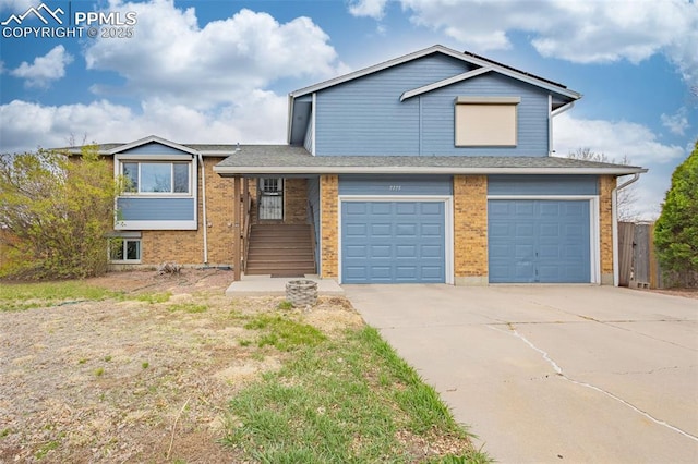 7775 Woody Creek Dr, Colorado Springs, CO 80911 - split level home with an attached garage, concrete driveway, brick siding, and roof with shingles