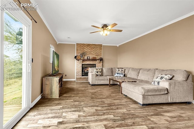 7775 Woody Creek Dr, Colorado Springs, CO 80911 - living area with crown molding, wood finished floors, a brick fireplace, baseboards, and ceiling fan