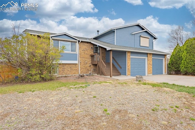 7775 Woody Creek Dr, Colorado Springs, CO 80911 - tri-level home with driveway, brick siding, and a garage