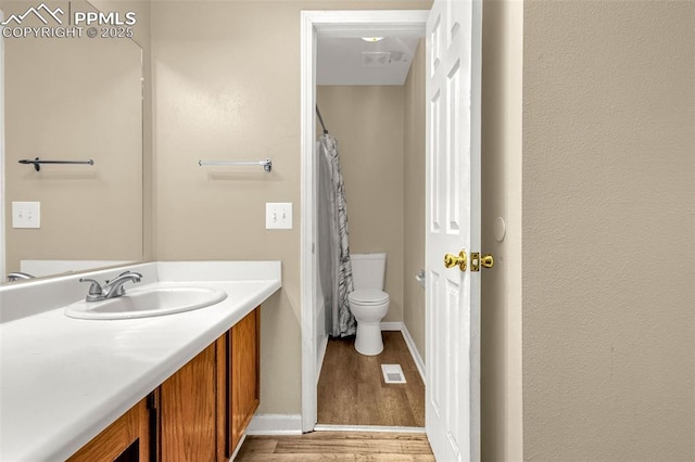 7775 Woody Creek Dr, Colorado Springs, CO 80911 - bathroom featuring vanity, toilet, baseboards, visible vents, and wood finished floors