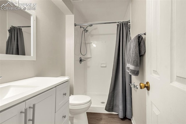 7775 Woody Creek Dr, Colorado Springs, CO 80911 - bathroom with toilet, vanity, wood finished floors, and a shower stall