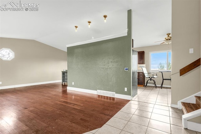 7775 Woody Creek Dr, Colorado Springs, CO 80911 - unfurnished living room featuring vaulted ceiling, wood finished floors, baseboards, visible vents, and ceiling fan