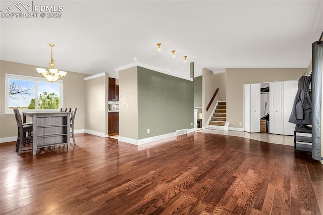 7775 Woody Creek Dr, Colorado Springs, CO 80911 - living room with stairs, baseboards, visible vents, a notable chandelier, and wood finished floors