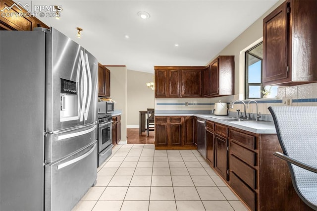 7775 Woody Creek Dr, Colorado Springs, CO 80911 - kitchen featuring light countertops, light tile patterned floors, a sink, dark brown cabinets, and appliances with stainless steel finishes