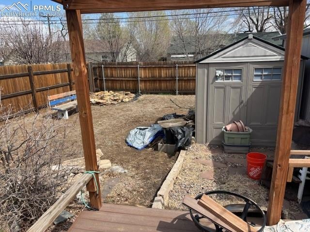 view of yard with an outdoor structure, a fenced backyard, and a storage shed