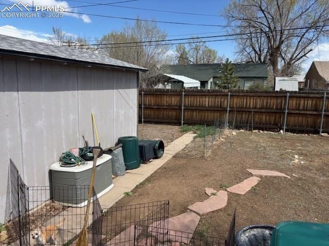 view of yard with a fenced backyard and an outbuilding