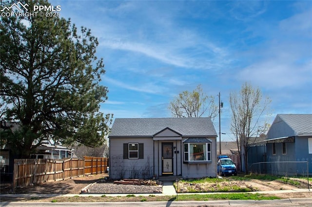 bungalow-style home featuring fence