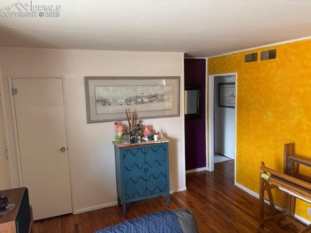 corridor with visible vents, baseboards, and wood finished floors