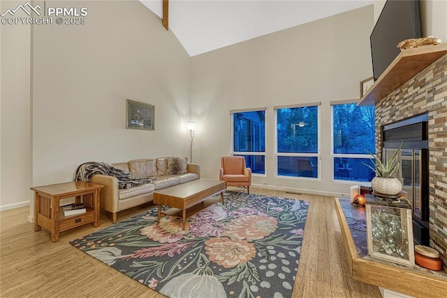 2372 Wood Ave, Colorado Springs, CO 80907 - living room with high vaulted ceiling, baseboards, a fireplace, and wood finished floors