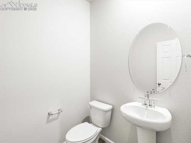 half bathroom with toilet and a sink