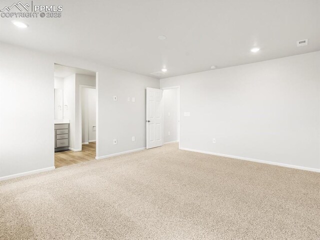 spare room with visible vents, baseboards, recessed lighting, and light colored carpet