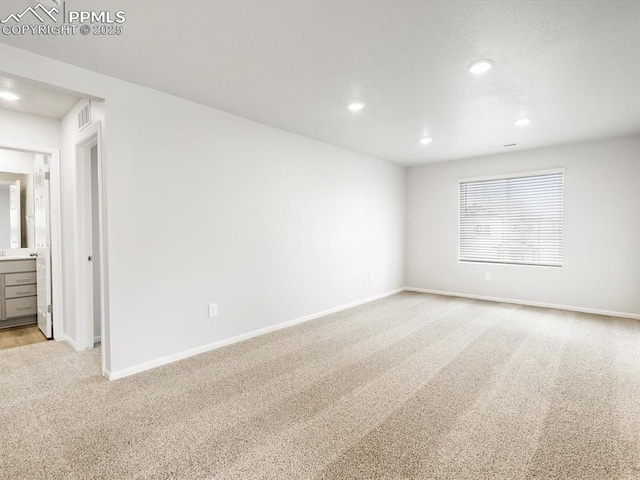 empty room with recessed lighting, baseboards, and light carpet