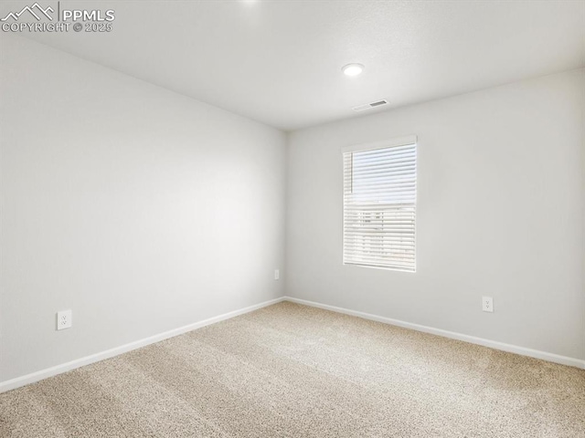 empty room featuring carpet floors, visible vents, and baseboards