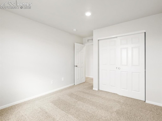 unfurnished bedroom featuring recessed lighting, visible vents, a closet, baseboards, and carpet flooring