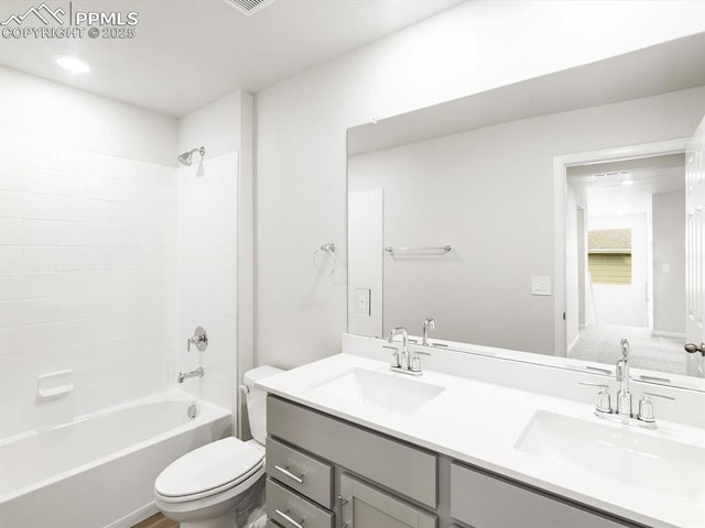 bathroom featuring shower / bath combination, a sink, double vanity, and toilet