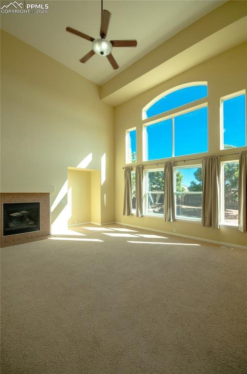 9443 St George Rd, Peyton, CO 80831 - unfurnished living room with a tiled fireplace, ceiling fan, and carpet flooring