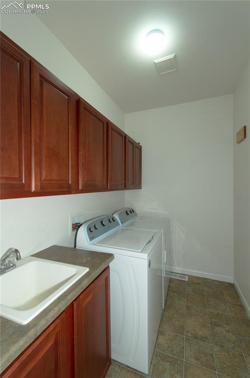 9443 St George Rd, Peyton, CO 80831 - laundry area with visible vents, a sink, washer and dryer, baseboards, and cabinet space