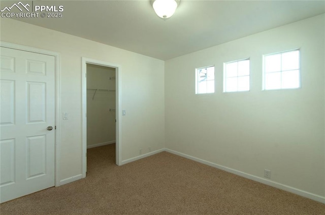 9443 St George Rd, Peyton, CO 80831 - unfurnished bedroom with baseboards, multiple windows, a walk in closet, and carpet floors