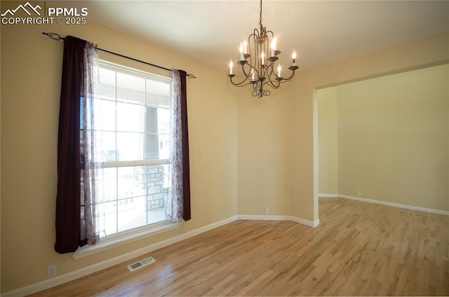 9443 St George Rd, Peyton, CO 80831 - empty room featuring visible vents, baseboards, an inviting chandelier, and light wood-style floors