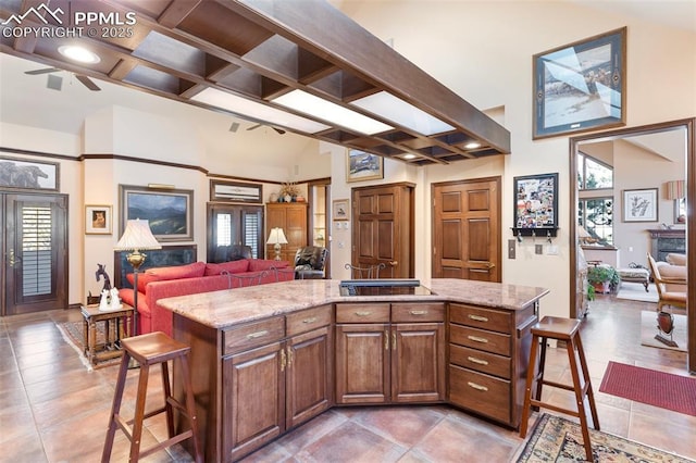 714 Southern Cross Pl, Colorado Springs, CO 80906 - kitchen featuring open floor plan, a center island, a ceiling fan, and light stone countertops