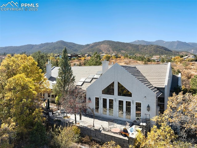 714 Southern Cross Pl, Colorado Springs, CO 80906 - back of property featuring a patio, french doors, a mountain view, and a chimney