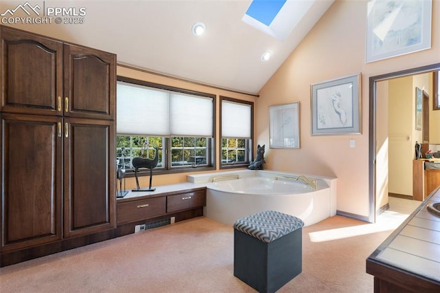 714 Southern Cross Pl, Colorado Springs, CO 80906 - bathroom featuring a bath, vaulted ceiling with skylight, carpet, and visible vents