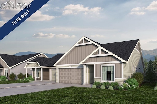view of front of home with a garage, concrete driveway, a front yard, board and batten siding, and a mountain view