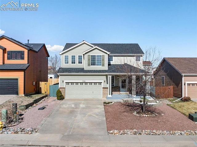 traditional home featuring an attached garage, fence, brick siding, a gate, and driveway