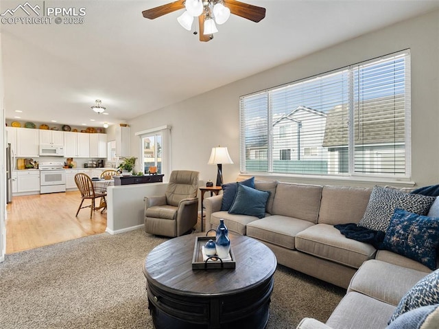 living room featuring a ceiling fan, light colored carpet, and recessed lighting