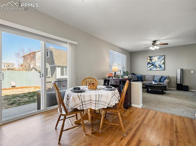dining area with light wood-type flooring, baseboards, and ceiling fan