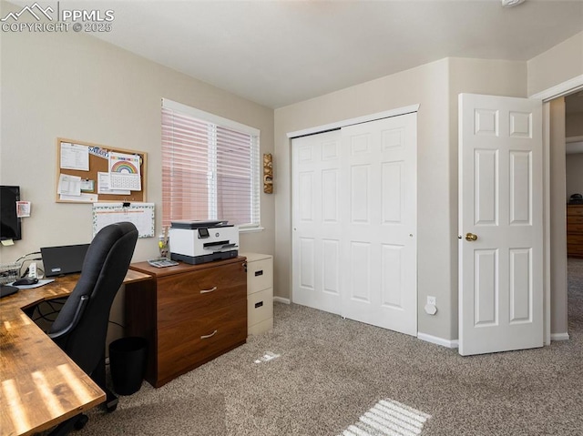 carpeted office space featuring baseboards