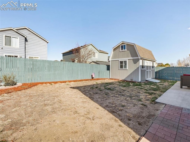 view of yard with a fenced backyard, an outdoor structure, and a shed